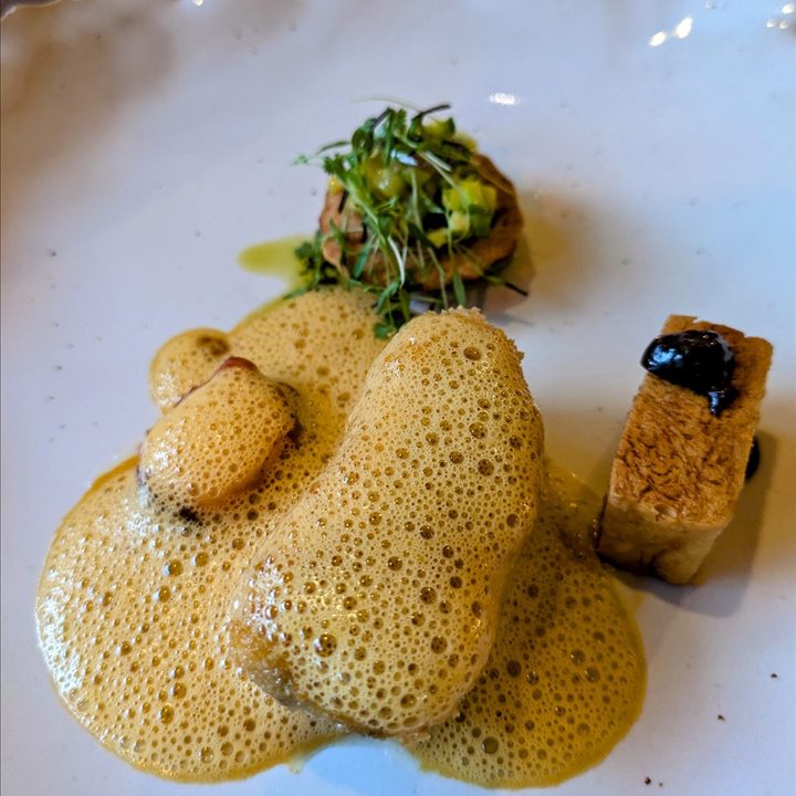 A small appetizer with a garnish and crisp pieces.